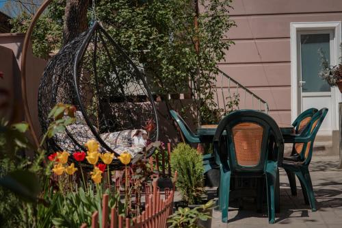 a patio with a swing and chairs and flowers at Family Hotel Mountain Scream in Tbilisi City