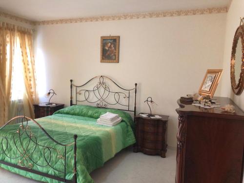a bedroom with a green bed and two night stands at B&B Alberobello Belvedere in Alberobello