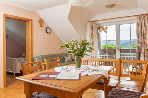 a living room with a wooden table with flowers on it at Ferienwohnungen am Ferienhof Schiegl - gerne auch Handwerker, Monteure in Brennberg
