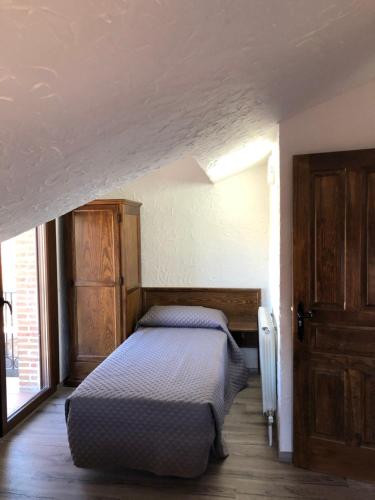 une chambre avec un lit et une grande fenêtre dans l'établissement casa de las Viñas 1 y 2, à Navaluenga