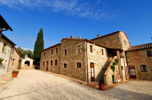 a large stone building with a staircase on the side at Relais Borgo Torale in Passignano sul Trasimeno