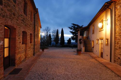 an empty alley with buildings and trees at night at Relais Borgo Torale in Passignano sul Trasimeno
