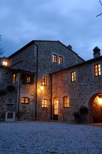 a large stone building with its lights on at Relais Borgo Torale in Passignano sul Trasimeno