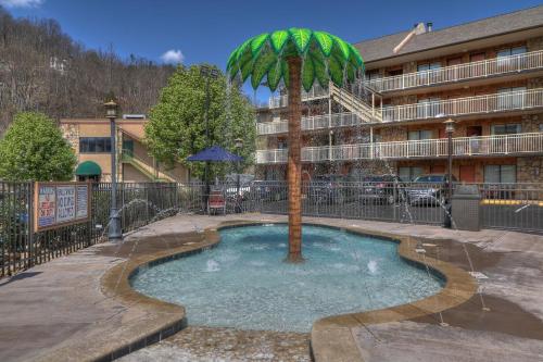 a small pool with a palm tree in front of a building at Crossroads Inn & Suites in Gatlinburg