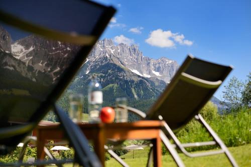 a table and chairs with a view of a mountain at Hotel Der Bär in Ellmau