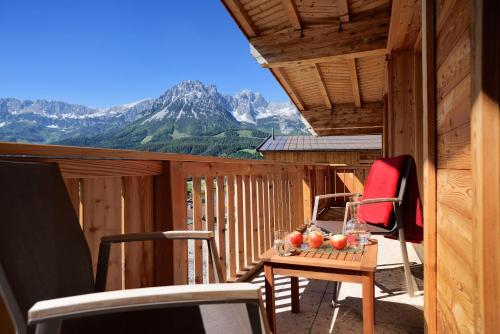 a room with a table and chairs on a balcony at Hotel Der Bär in Ellmau