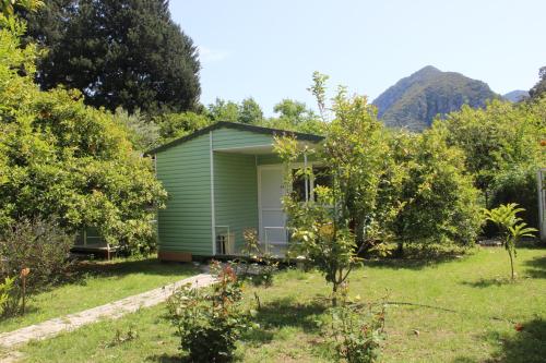 a green house in the middle of a yard at Saklı Bahçe Pension in Cıralı