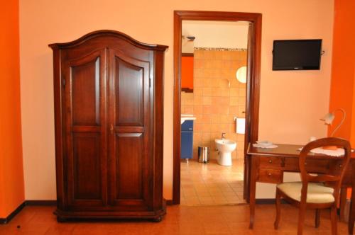 a bathroom with a wooden door and a desk and a toilet at L' Aia Antica in Veroli