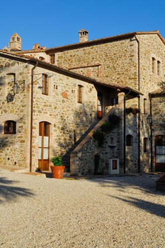 a large stone building with a courtyard in front of it at Relais Borgo Torale in Passignano sul Trasimeno