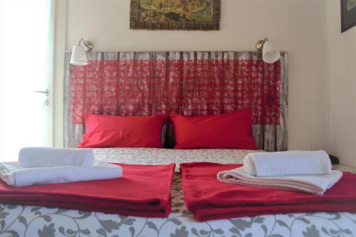 a bedroom with red pillows and red pillows on a bed at B&B Cappuccini in Schio