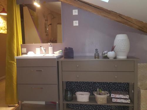 a bathroom with a sink and a vanity with a mirror at Chambre d'hôtes in Chiré-en-Montreuil