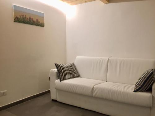 a white couch in a living room with a painting on the wall at IL VIAGGIATORE VIA INDIPENDENZA 2 in Gaeta