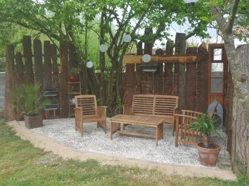 a group of chairs and a bench in front of a fence at Chambre d'hôtes chez Denis et Margot in Chiré-en-Montreuil
