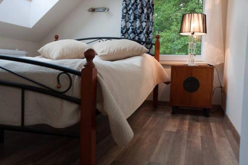 a bedroom with a bed with a lamp and a window at Bobrowa Przystań in Czechyń
