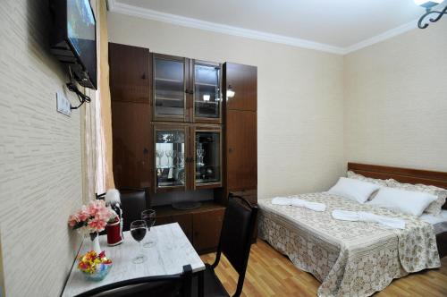 um quarto de hotel com uma cama e uma mesa com uma mesa sidx sidx em Apartment Albatross em Tbilisi
