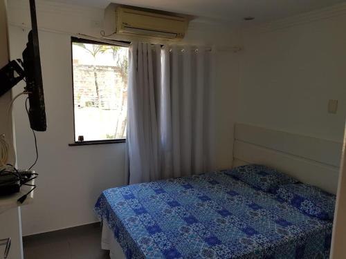 a small bedroom with a bed and a window at Apto na Praia de Guaibim in Guaibim