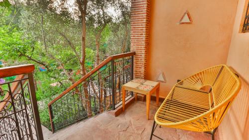 a porch with a chair and a table on a balcony at ferme by Ikalimo in Ourika