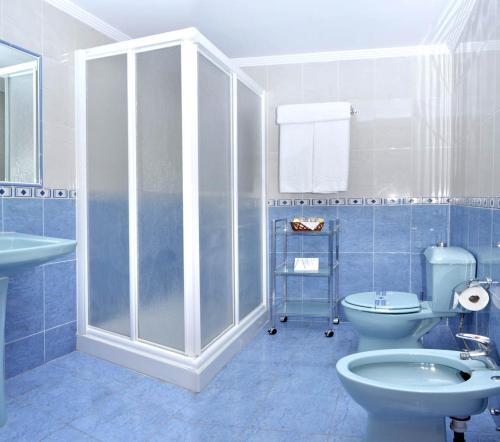 La salle de bains bleue est pourvue de toilettes et d'un lavabo. dans l'établissement Arrayanes Playa Almuñecar, à Almuñécar