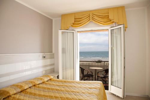 1 dormitorio con cama y vistas al océano en Hotel Righetto Fronte Mare, en Cavallino-Treporti