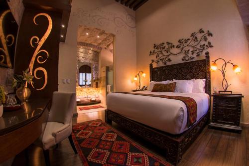 a bedroom with a bed and a table and a mirror at Hotel De La Soledad in Morelia