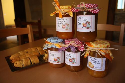een groep van vier potten jam op een tafel met brood bij Aperanti Agrotourism in Pera Orinis