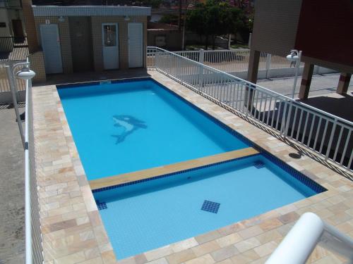 a large blue swimming pool with a rail around it at Condomínio Pedra Coral in Ubatuba