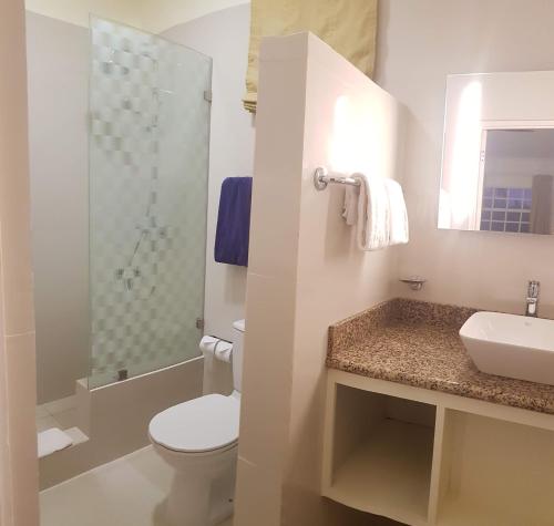 y baño con aseo, lavabo y ducha. en Blue Horizons Garden Resort, en Saint George