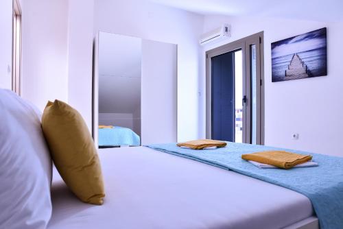 a bedroom with a large white bed with a window at Apartments Svijet Mora in Povljana
