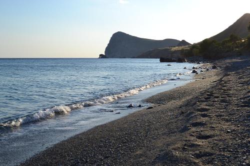 a beach with a group of people on the water at Sofia Apartment in Léntas