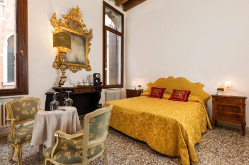 a bedroom with a bed and a table and chairs at Luxury Venetian Rooms in Venice