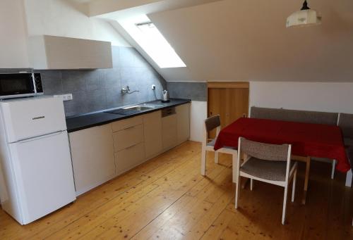 a kitchen and dining room with a table and a refrigerator at Apartmán Skalka in Mnichovo Hradiště