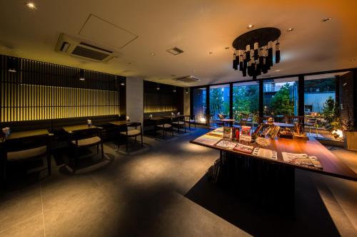 a restaurant with tables and chairs and large windows at Kyoto Itoya Hotel in Kyoto