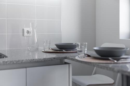 a kitchen with two plates and glasses on a counter at Green Villas Douro in Gondomar