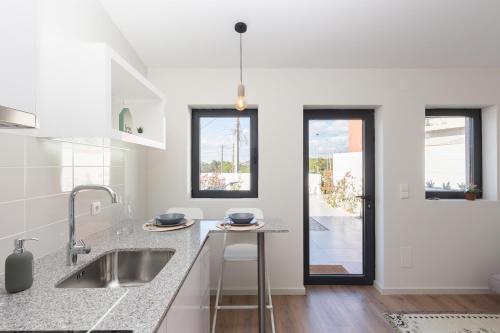 a white kitchen with a sink and a counter at Green Villas Douro in Gondomar