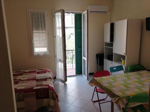 een kamer met een tafel en een deur naar een balkon bij Appartamento per vacanze GAIA in Monterosso al Mare