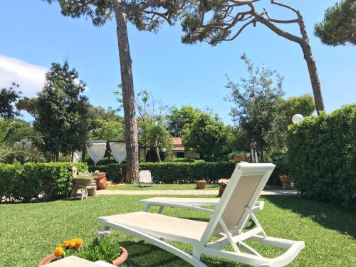 a white lawn chair sitting in a yard at Il Miraggio in Fregene
