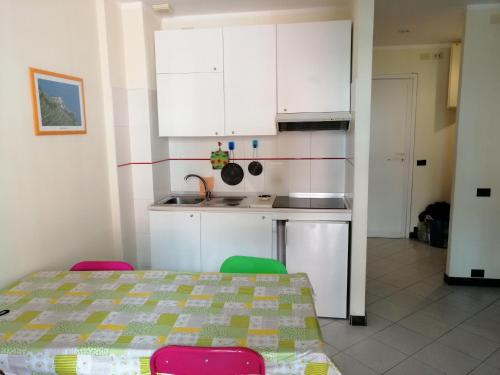 een keuken met witte kasten en een tafel en stoelen bij Appartamento per vacanze GAIA in Monterosso al Mare