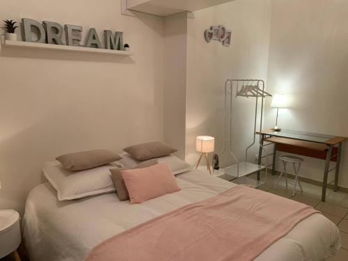 a bedroom with a large bed with a desk and a desk at CHARMANT T2 PROCHE CENTRE VILLE PLAGE JARDIN DIOR 50 m2 in Granville