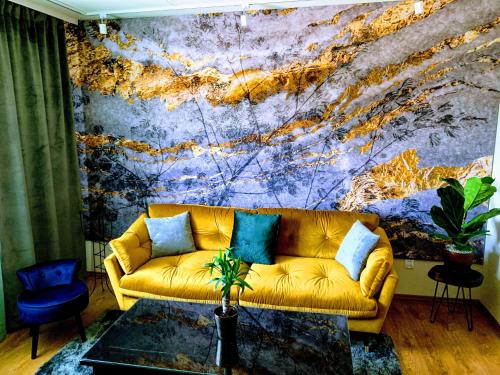 クドヴァ・ズドゥルイにあるApartament Gingerの壁の前に黄色のソファが置かれたリビングルーム
