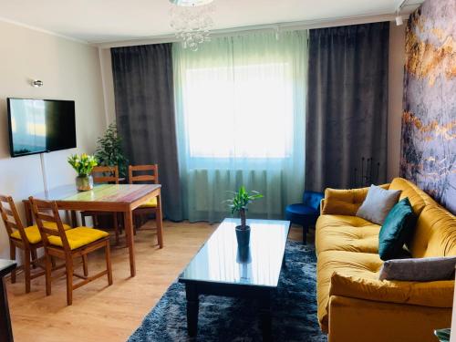 uma sala de estar com um sofá e uma mesa em Apartament Ginger em Kudowa-Zdrój