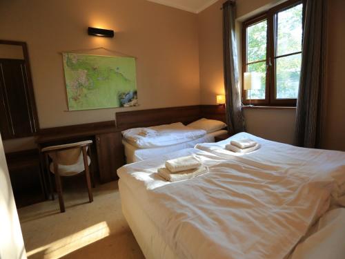 a bedroom with two beds with towels on them at Pensjonat Bajdarka in Suraż