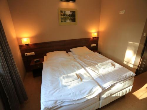 a bedroom with a large bed with white sheets and pillows at Pensjonat Bajdarka in Suraż