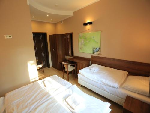 a hotel room with two beds and a desk at Pensjonat Bajdarka in Suraż