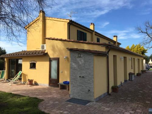 a yellow building with a door on the side of it at Podere Gabry in Arena Metato