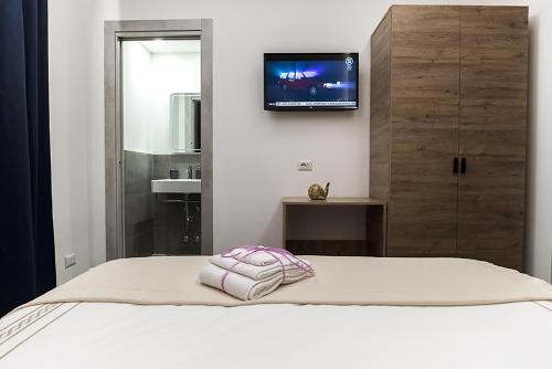 1 dormitorio con 1 cama y TV en la pared en My Love Suite en Roma