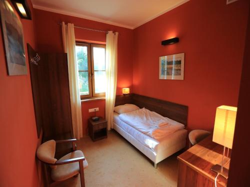 a small bedroom with a bed and a window at Pensjonat Bajdarka in Suraż