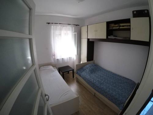 ein kleines Schlafzimmer mit 2 Betten und einem Fenster in der Unterkunft Apartment Mrak in Lovran