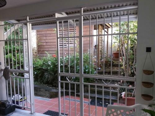 a gate in a house with a garden behind it at Grand F2, spa, jardin, parking in Schœlcher