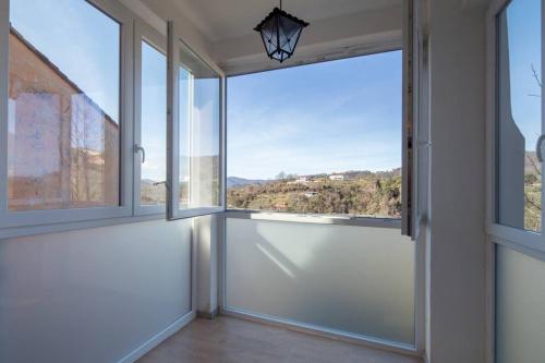 an empty room with large windows with a view at Casa Sterinella in Follo Alto