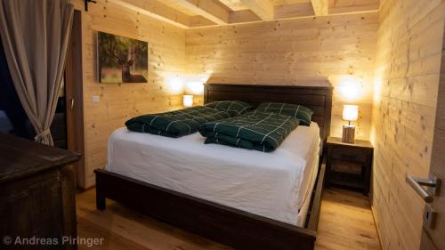 a bedroom with a bed with two green pillows at Chalet Hirsch - Lachtal 533 in Oberwölz Stadt